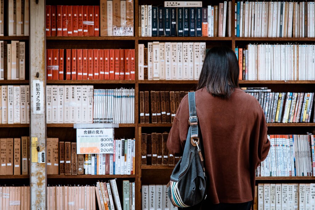 Student browsing books in university library.