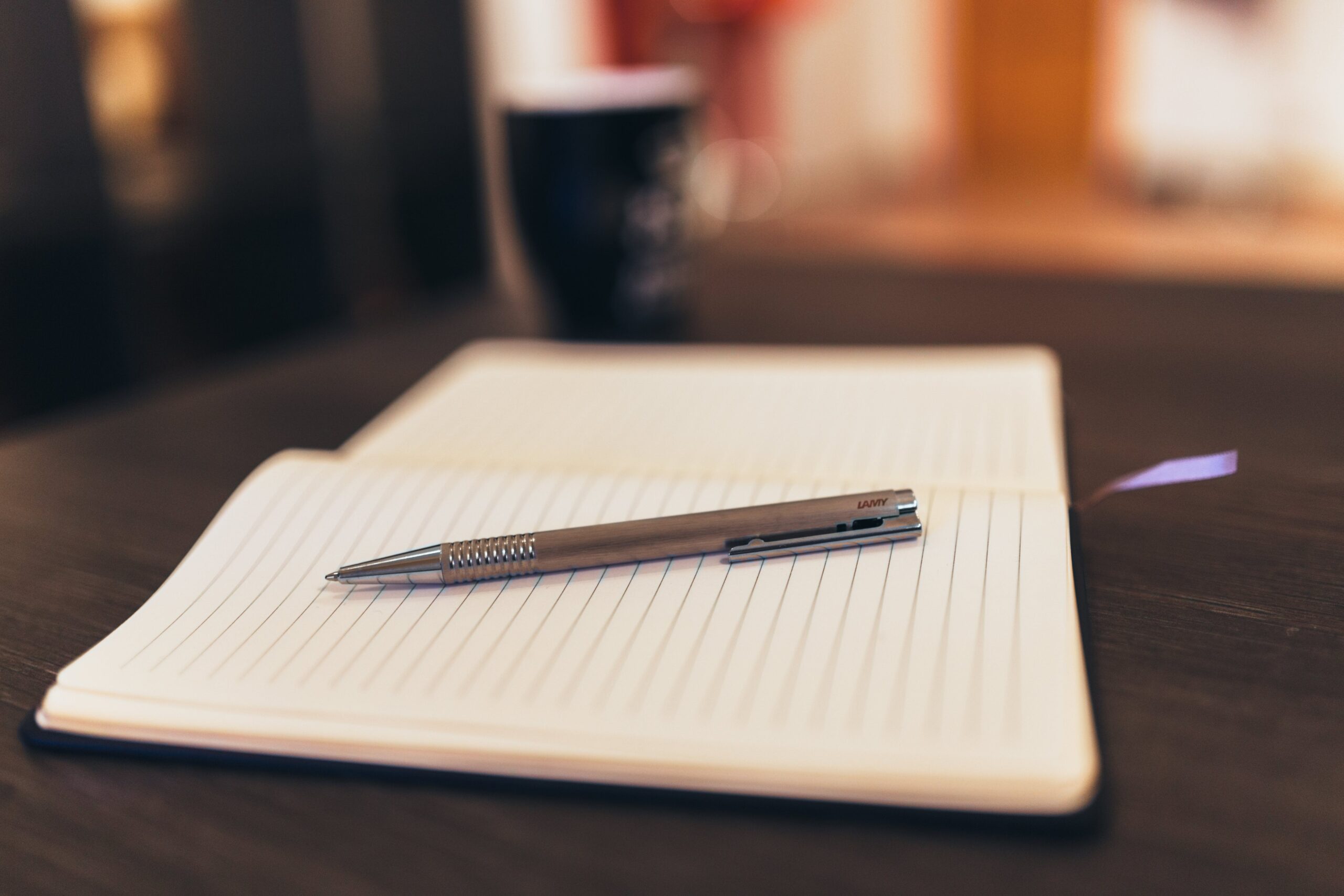 Notebook and pencil on wooden table.