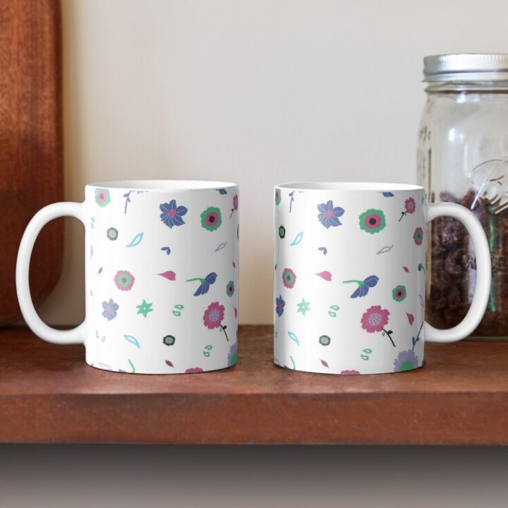 Two ceramic flower mugs featuring a wraparound white and pink floral pattern design. Designed by Zuzanii Designs.