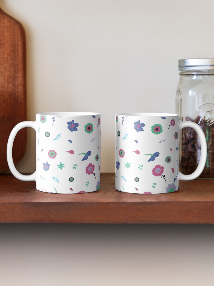 Two ceramic flower mugs featuring a wraparound white and pink floral pattern design. Designed by Zuzanii Designs.