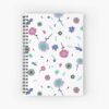 A spiral A5 notebook featuring a white and pink floral front cover print by independent designer Zuzanii Designs.