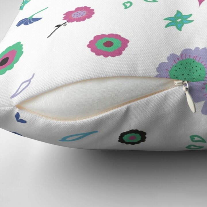 Close-up of concealed zip opening on throw pillow featuring an original white and pink floral pattern, made with a 100% spun polyester cover. One of many floral pillowcases designed by independent artist Zuzanii Designs.