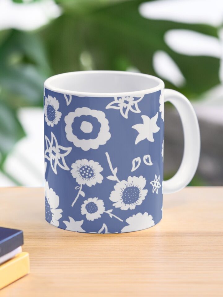 Ceramic flower mug featuring a wraparound blue and white floral pattern design. Designed by Zuzanii Designs.