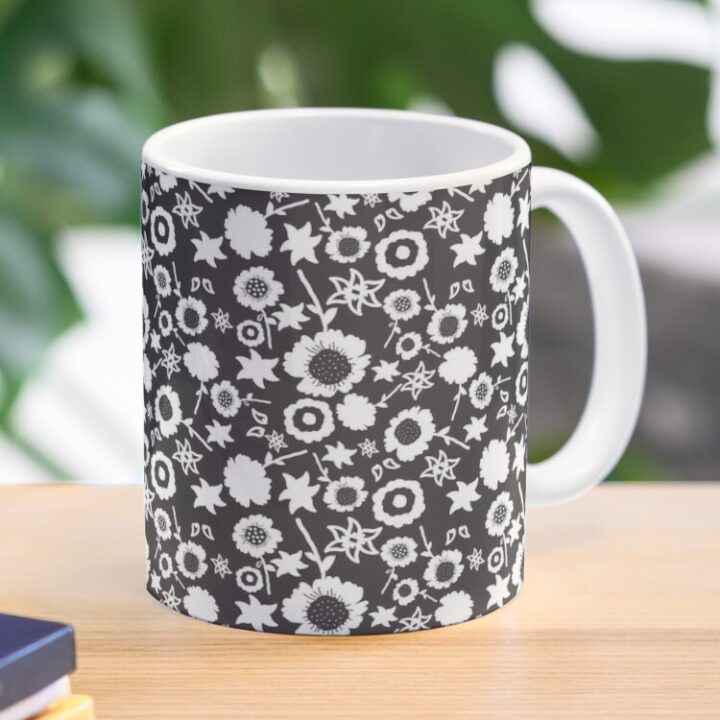 Ceramic flower mug featuring a wraparound black and white floral pattern design. Designed by Zuzanii Designs.